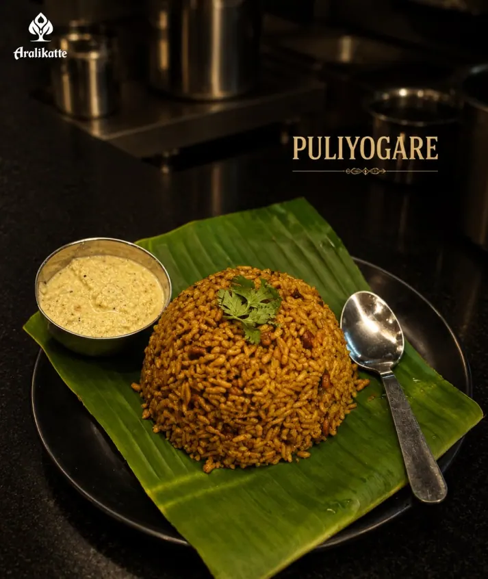 Puliyogare (tamarind rice) with coconut chutney on a banana leaf