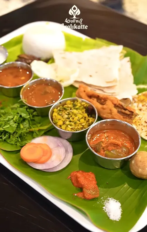 Banana-leaf meals plate with curries, sides and papad in steel bowls